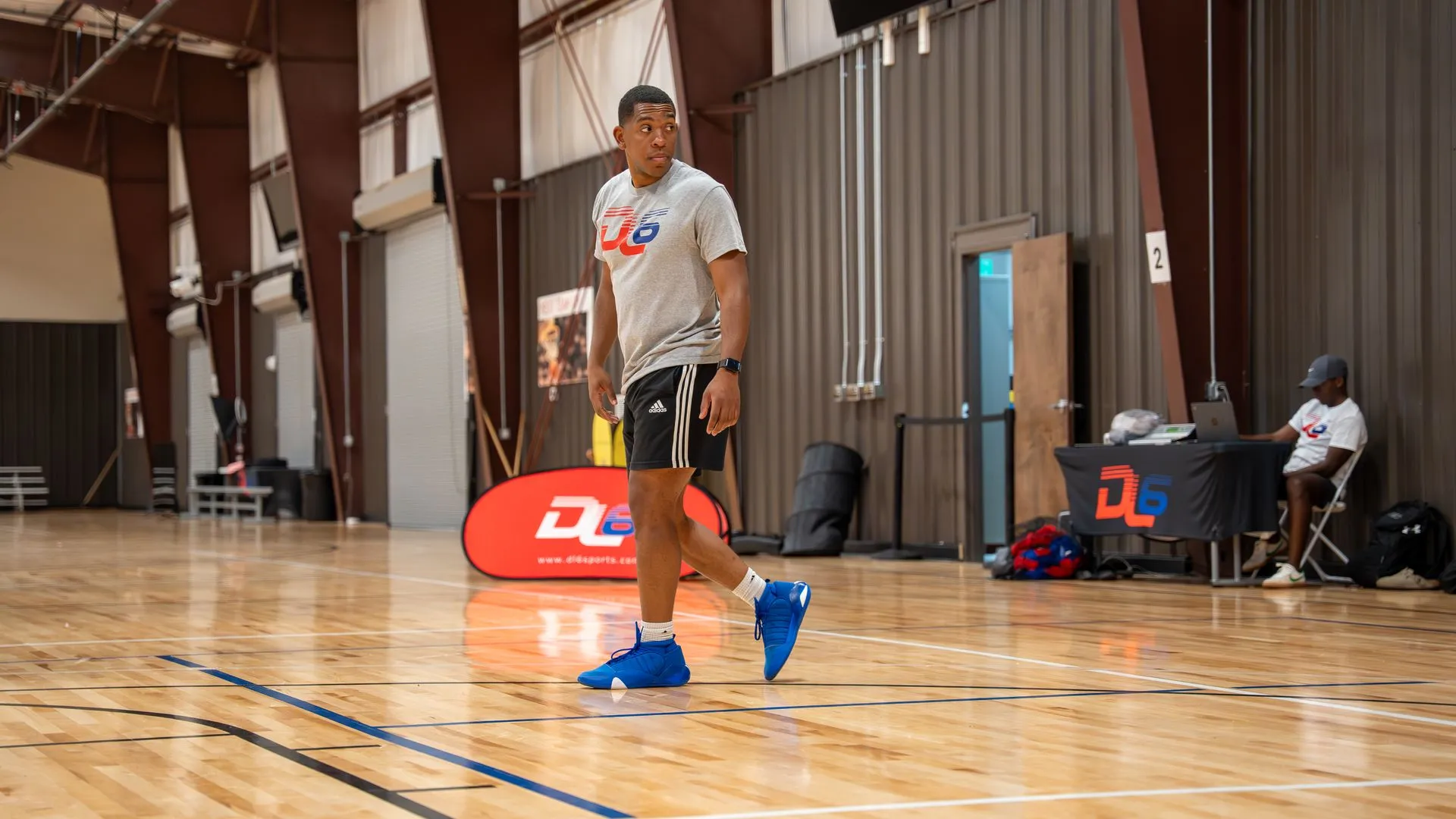 Coach training young athlete on basketball court